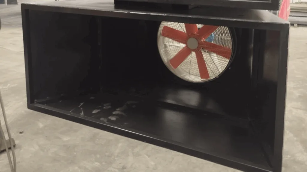 Ventilador con aspas naranjas y caja negra.